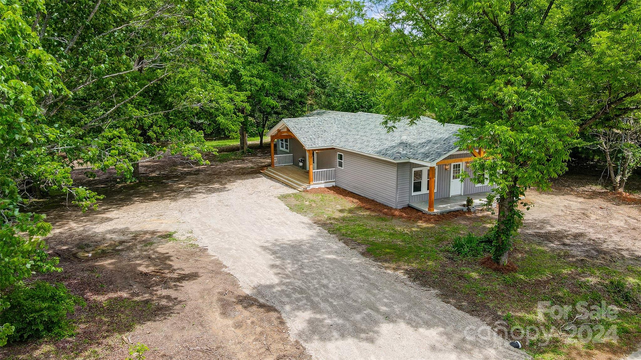 1129 Duckwood Road Lancaster, SC 29720 - Photo 5 of 48 a white house covered with tall trees