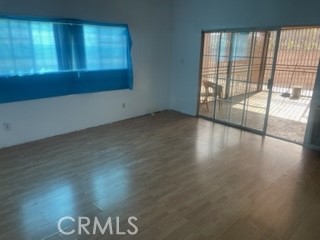 1540 South Pearl Avenue Compton, CA 90221 - Photo 4 of 6 a view of an empty room with wooden floor and a window