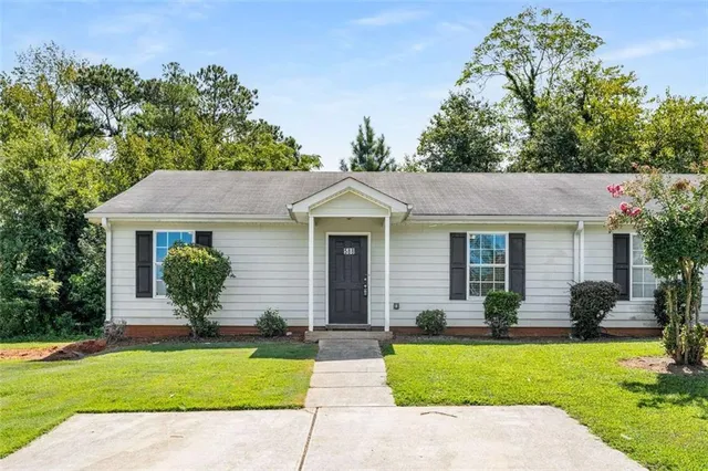 a front view of a house with a yard and potted plants