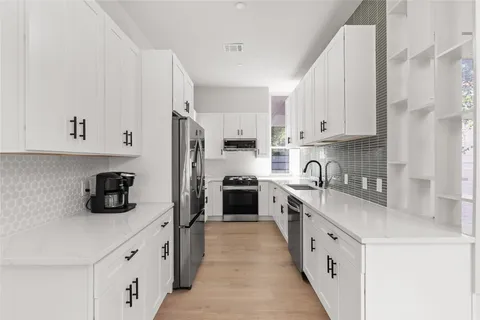 a kitchen with white cabinets and white appliances