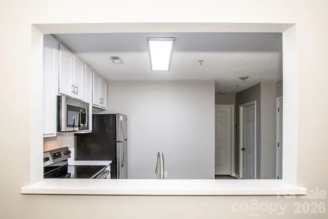 a kitchen with stainless steel appliances a refrigerator and microwave