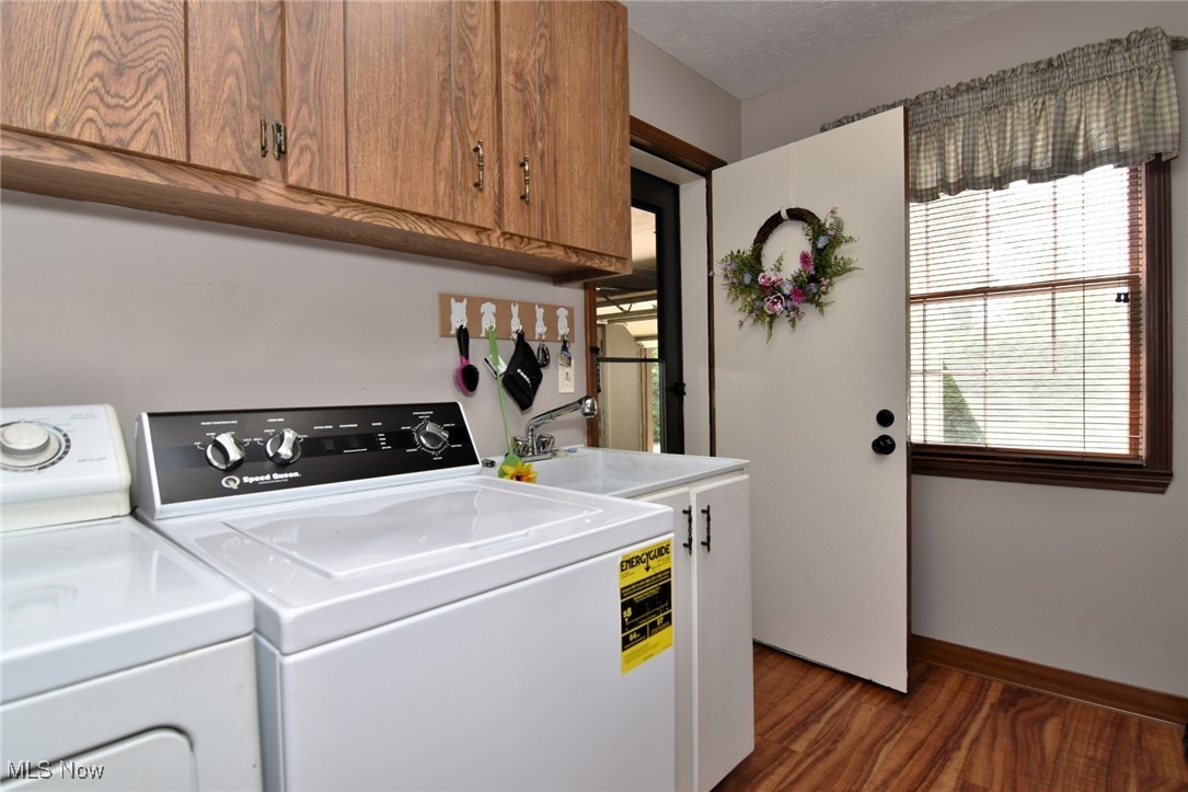 5510 Som Center Road Solon, OH 44139 - Photo 12 of 38 Laundry room with cabinet space, wood finished floors, baseboards, and washing machine and dryer