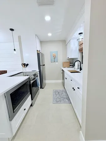 a kitchen with stainless steel appliances kitchen island a stove a sink and a refrigerator