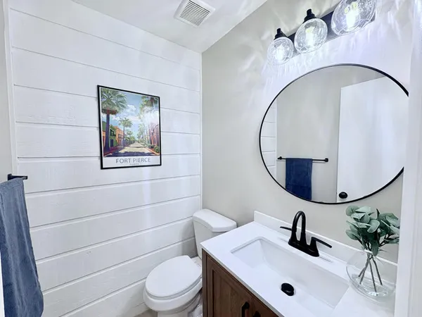 a bathroom with a sink mirror and toilet
