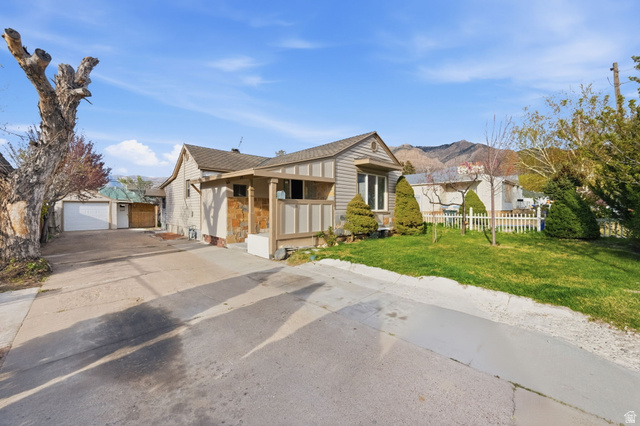 708 9th Street Ogden, UT 84404 - Photo 2 of 17 View of front of home with an outbuilding, a detached garage, a mountain view, and a shingled roof
