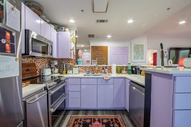 a kitchen with stainless steel appliances a stove microwave and sink