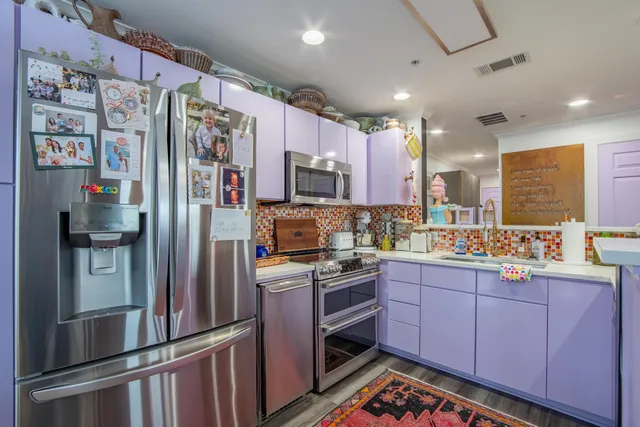 a dining room with stainless steel appliances lots of furniture and wooden floor