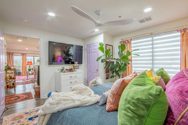 a bedroom with a bed dresser and a flat tv screen