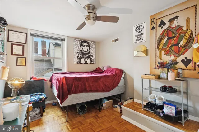 a bedroom with a bed and wooden floor