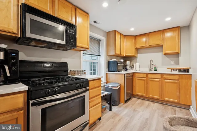 a kitchen with stainless steel appliances a stove microwave and sink