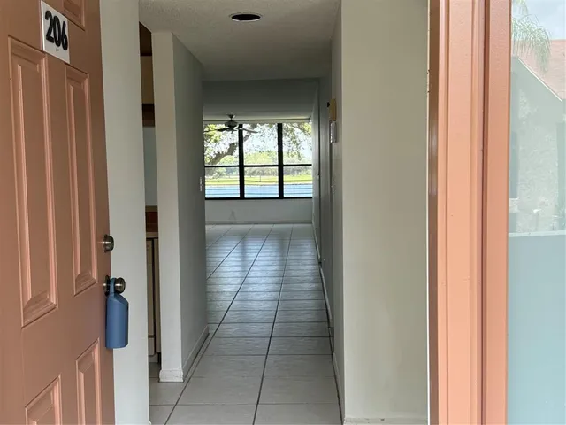 a hallway with wooden floor closet and livingroom