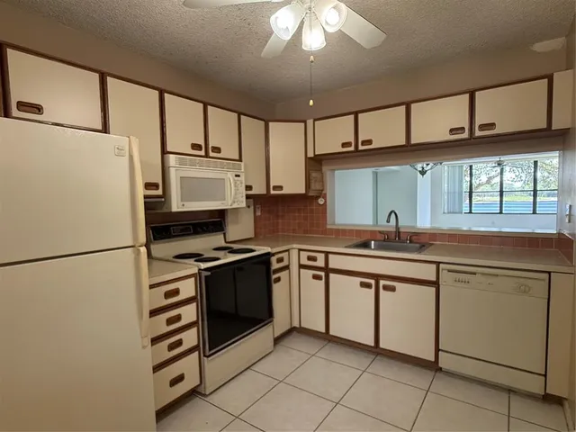 a kitchen with appliances a sink and cabinets