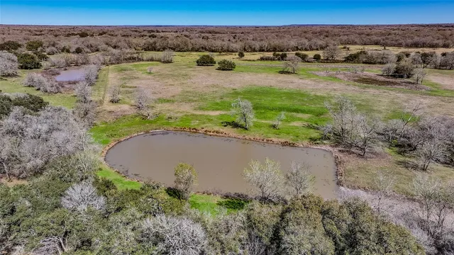 an aerial view of a house with a yard and lake view
