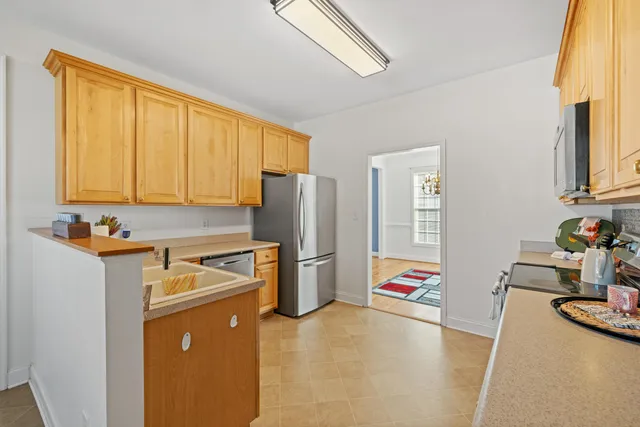 a view of a kitchen with fridge and workspace