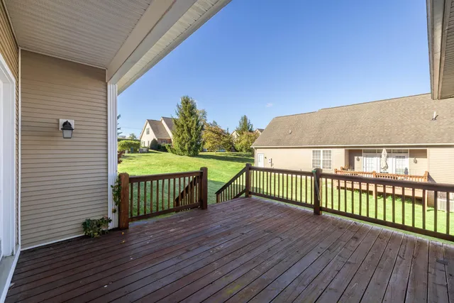 a front view of house with yard and trees in the background