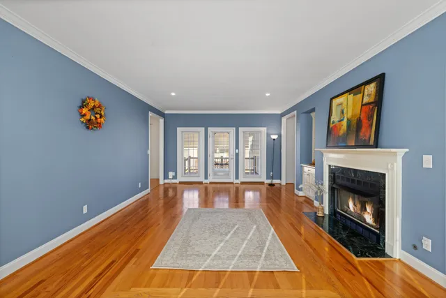 a view of empty room with fireplace and wooden floor