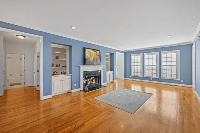 a view of empty room with wooden floor and fireplace