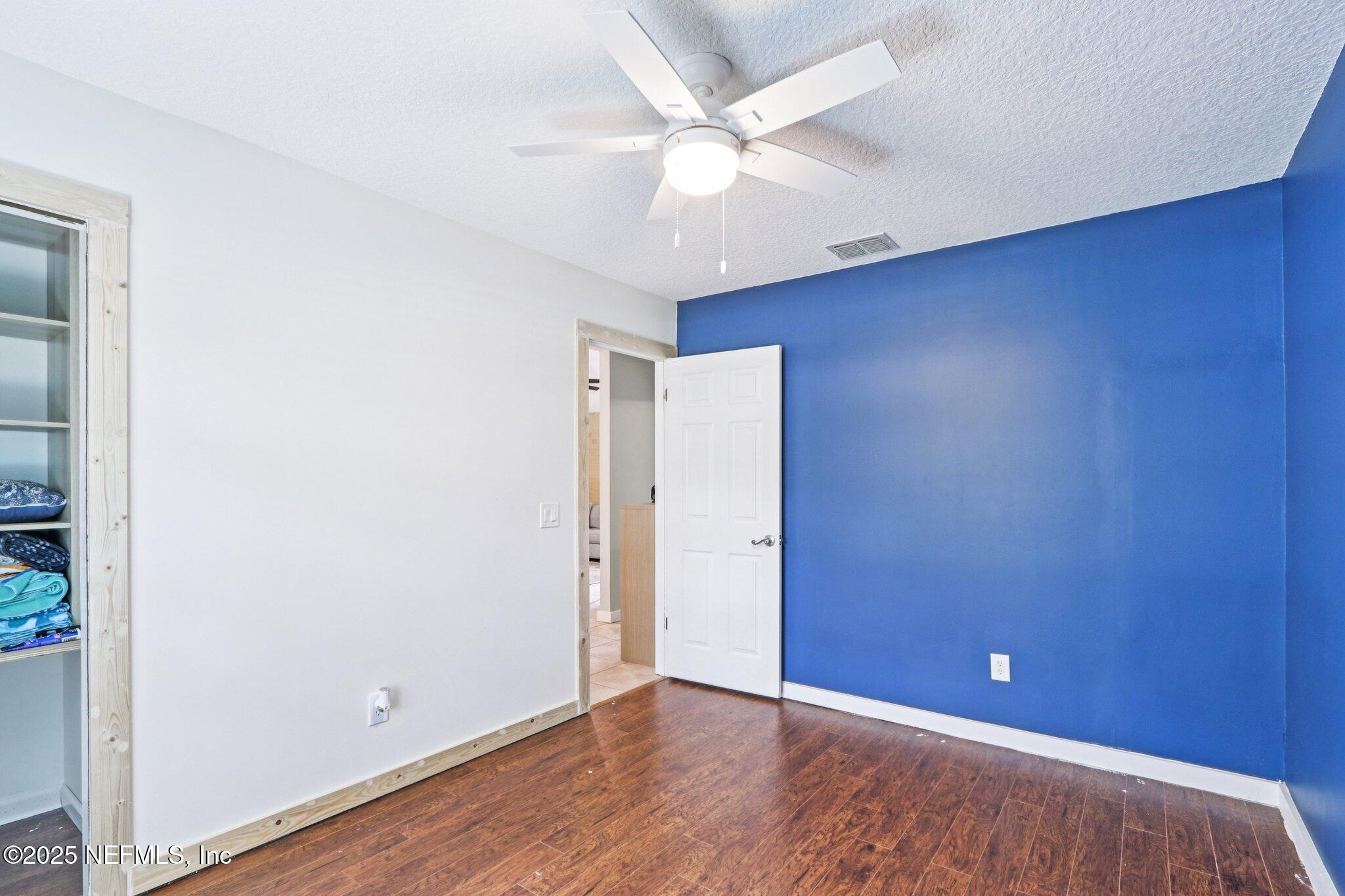 1649 Panther Ridge Court Jacksonville, FL 32225 - Photo 21 of 29 an empty room with wooden floor and fan