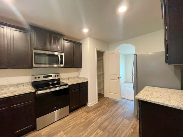 a kitchen with granite countertop stainless steel appliances and wooden cabinets
