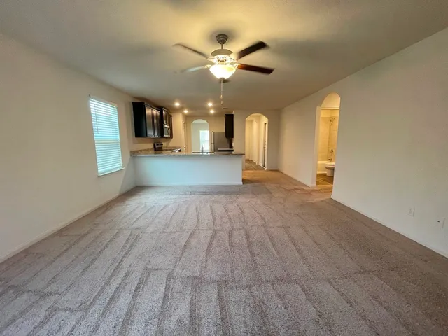 a view of a livingroom with a ceiling fan and window