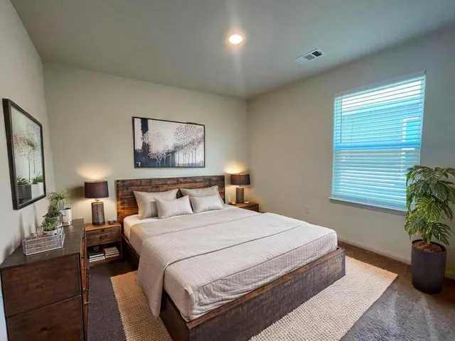 a bedroom with a large bed and a window