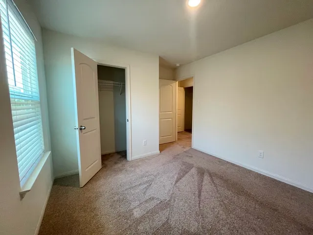 an empty room with closet and windows