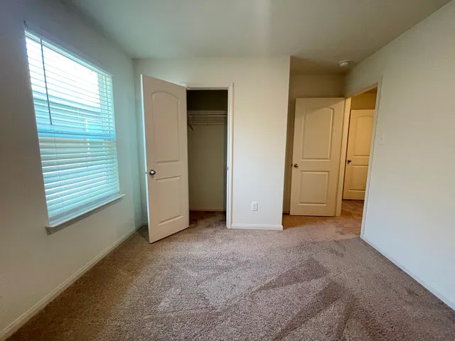 an empty room with closet and windows
