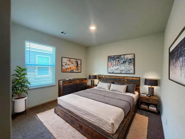 a bedroom with a bed and a potted plant
