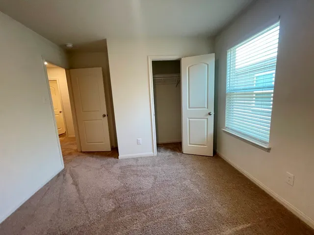 an empty room with windows and closet