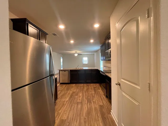 a view of a refrigerator in kitchen and wooden floor