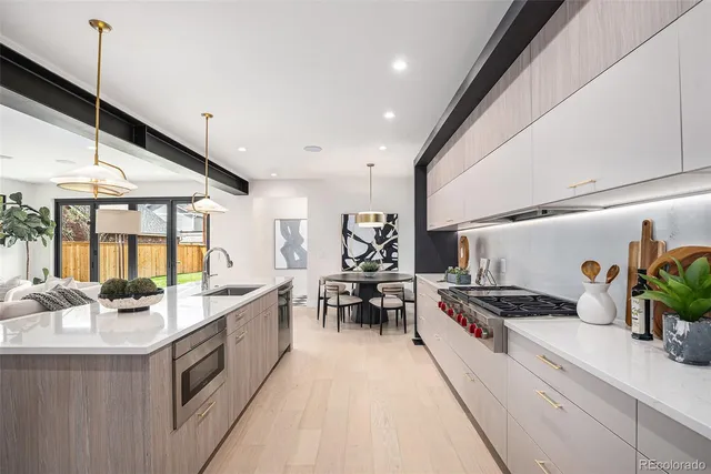 a kitchen with stainless steel appliances kitchen island sink stove and cabinets