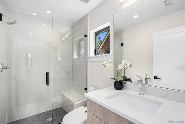 a bathroom with a sink a toilet and shower