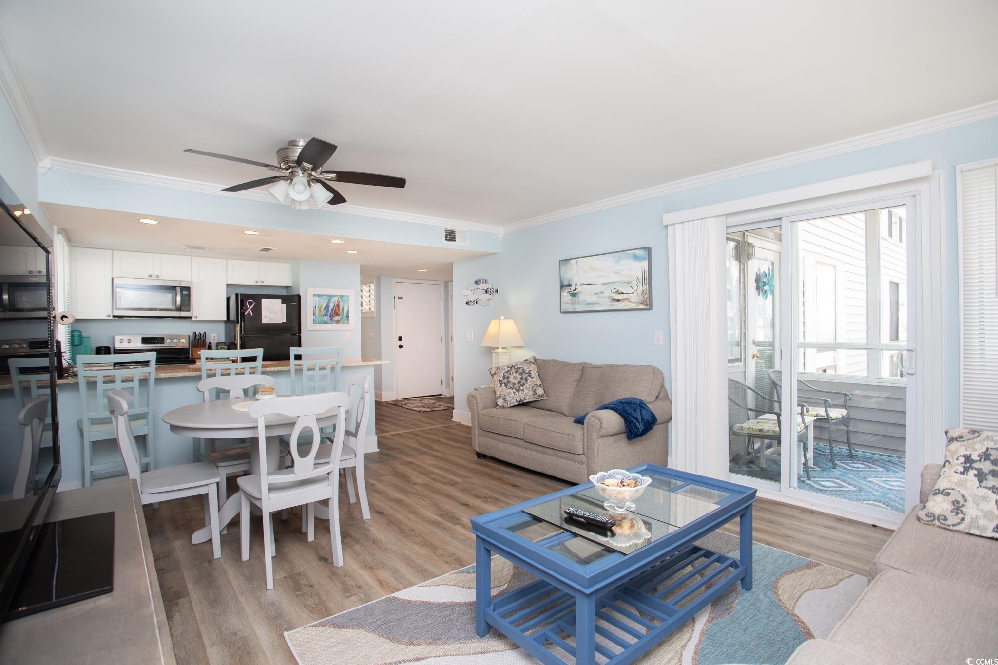Living room with light hardwood / wood-style floors, ornamental molding, and ceiling fan