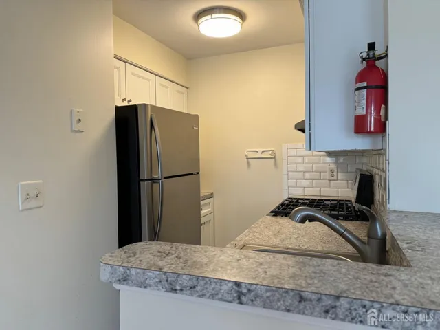 a kitchen with a refrigerator and a stove top oven