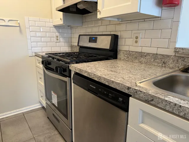 a kitchen with granite countertop a stove and a sink