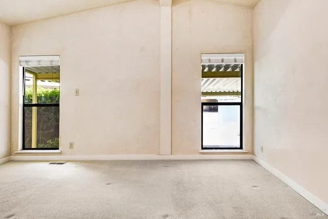 an empty room with windows and closet