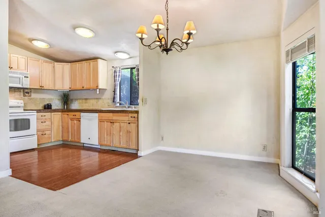 a kitchen with kitchen island a counter top space a sink stainless steel appliances and cabinets