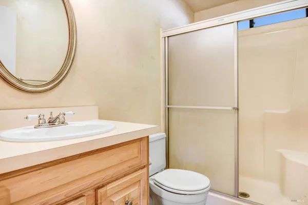 a bathroom with a granite countertop sink mirror vanity and toilet