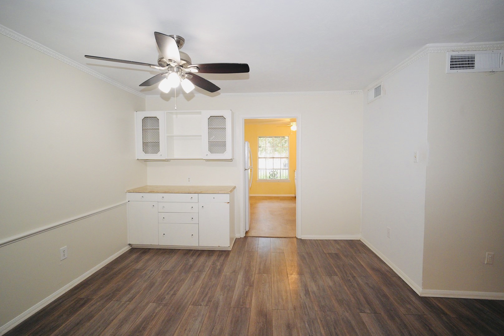 7600 Burgoyne Road, Unit 250 Houston, TX 77063 - Photo 7 of 14 This inviting dining area features elegant wood flooring, a stylish ceiling fan, and built-in cabinetry, offering a warm and functional space perfect for family gatherings.