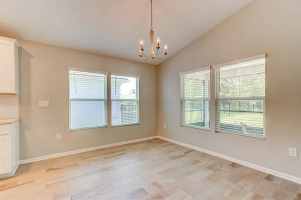 a view of empty room with wooden floor and ceiling fan