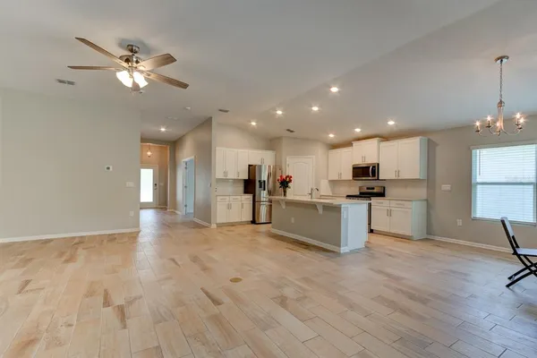 a view of kitchen with cabinets microwave and stove