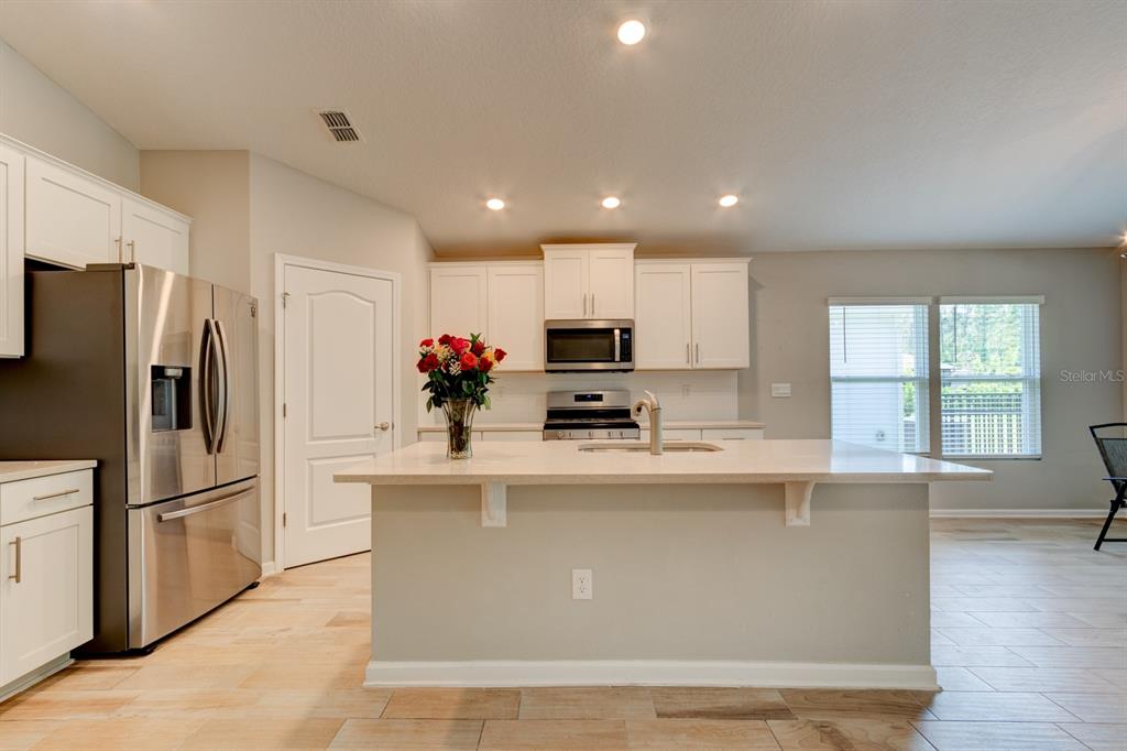 9 Ace Court Bunnell, FL 32110 - Photo 8 of 51 a kitchen with stainless steel appliances granite countertop a refrigerator a sink dishwasher a stove and white countertops with wooden floor