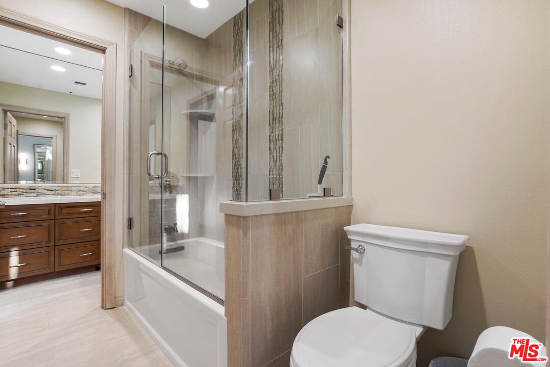 19 Ranchero Road Bell Canyon, CA 91307 - Photo 36 of 42 a bathroom with a granite countertop toilet a sink and a bathtub