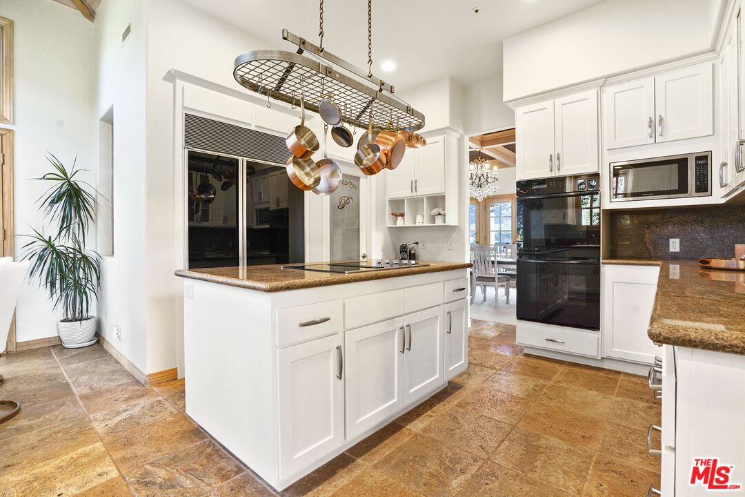 19 Ranchero Road Bell Canyon, CA 91307 - Photo 10 of 42 a kitchen with stainless steel appliances kitchen island granite countertop a refrigerator a stove and a sink