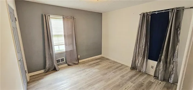 an empty room with wooden floor and entrance