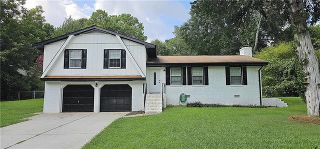 a front view of a house with a garden and yard