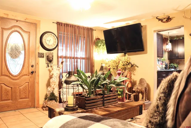 a living room with patio furniture and a flat screen tv