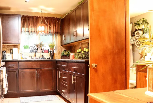 a kitchen with stainless steel appliances granite countertop a sink and wooden cabinets