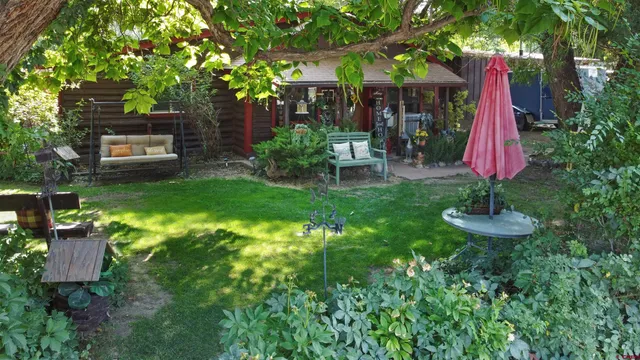 a view of a patio with table and chairs and a large tree