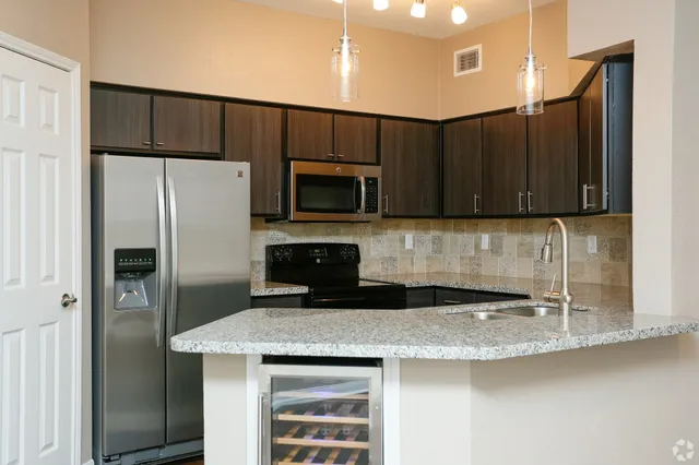 a kitchen with kitchen island a sink stainless steel appliances and cabinets